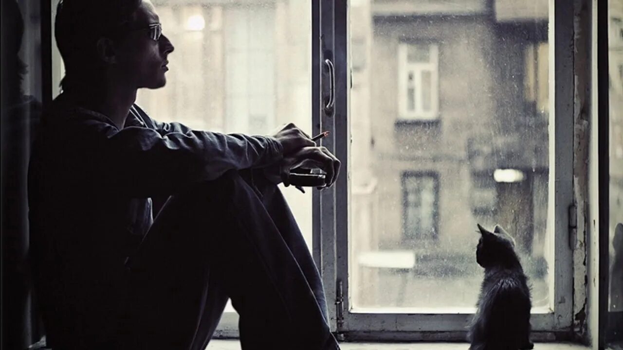 Он сидит грустным. Грустное окно. сидит у окна. парень у окна. парень сидит на окне.
