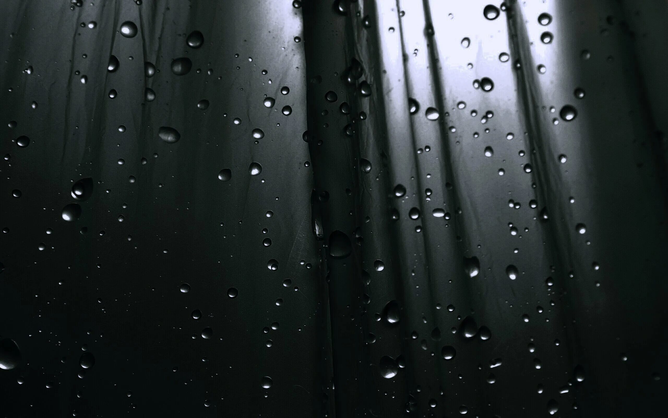 В темных каплях дождя. Капли на стекле. Капли воды на стекле. Дождь на черном фоне. Капли на черном фоне.