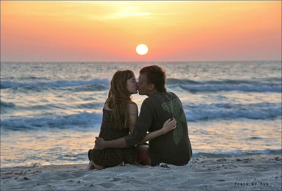 Влюбленные пары на море. Обнимаются на берегу моря. Влюбленная пара сидит на берегу моря. Пара обнимается на море.