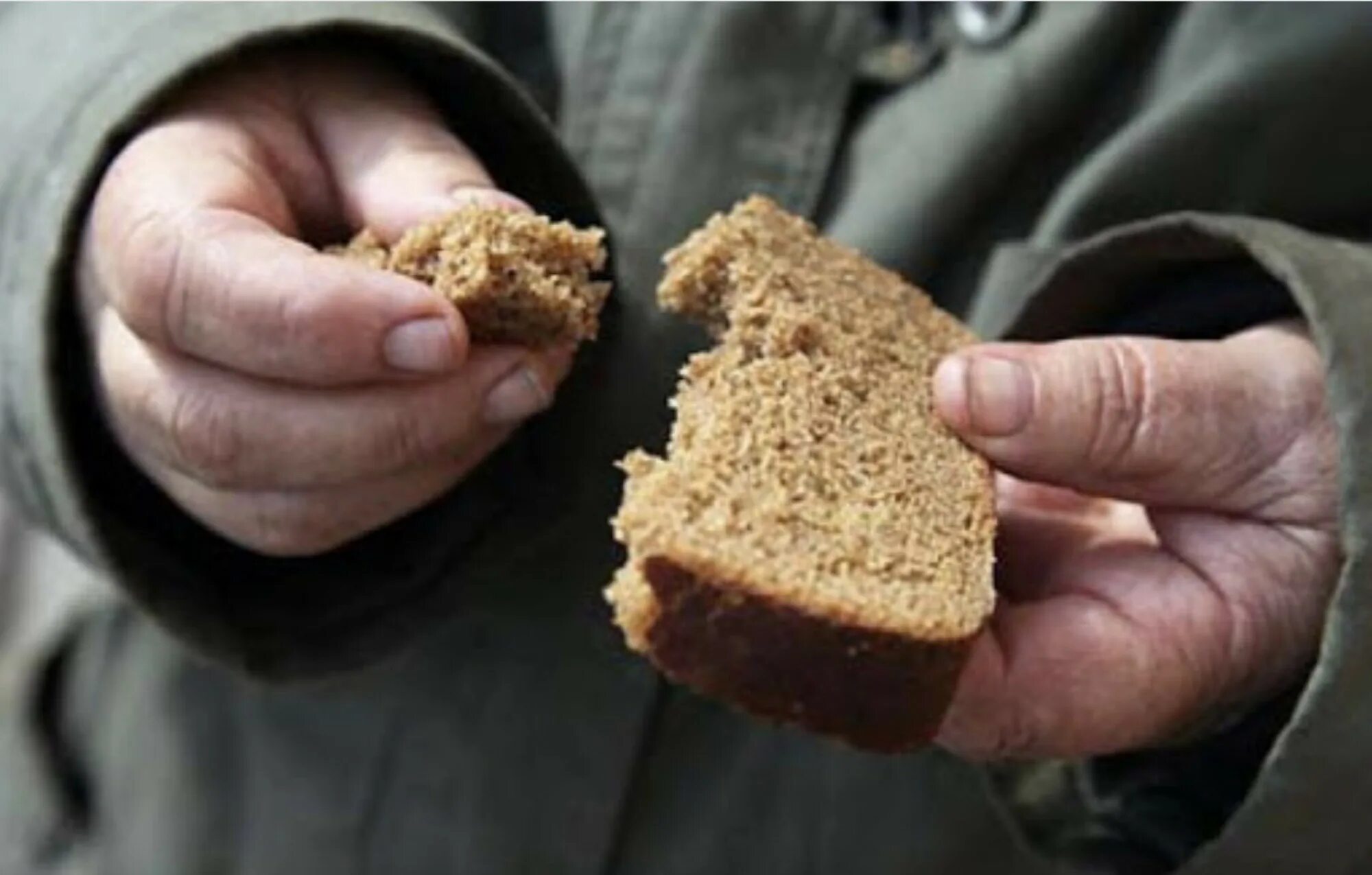 Хроническая бедность. Черствый кусок хлеба. Кусок хлеба в руке. Нищий с куском хлеба. Нехватка еды.