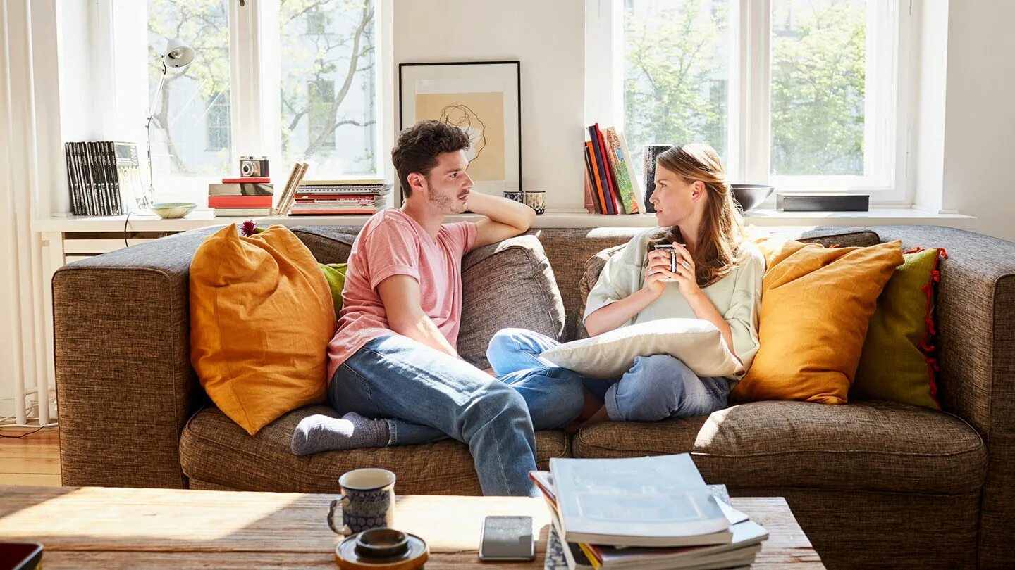 There are people in the room. Мужчина и женщина в комнате. Man sitting in Living Room. People in Living Room. Предложения с at Home.
