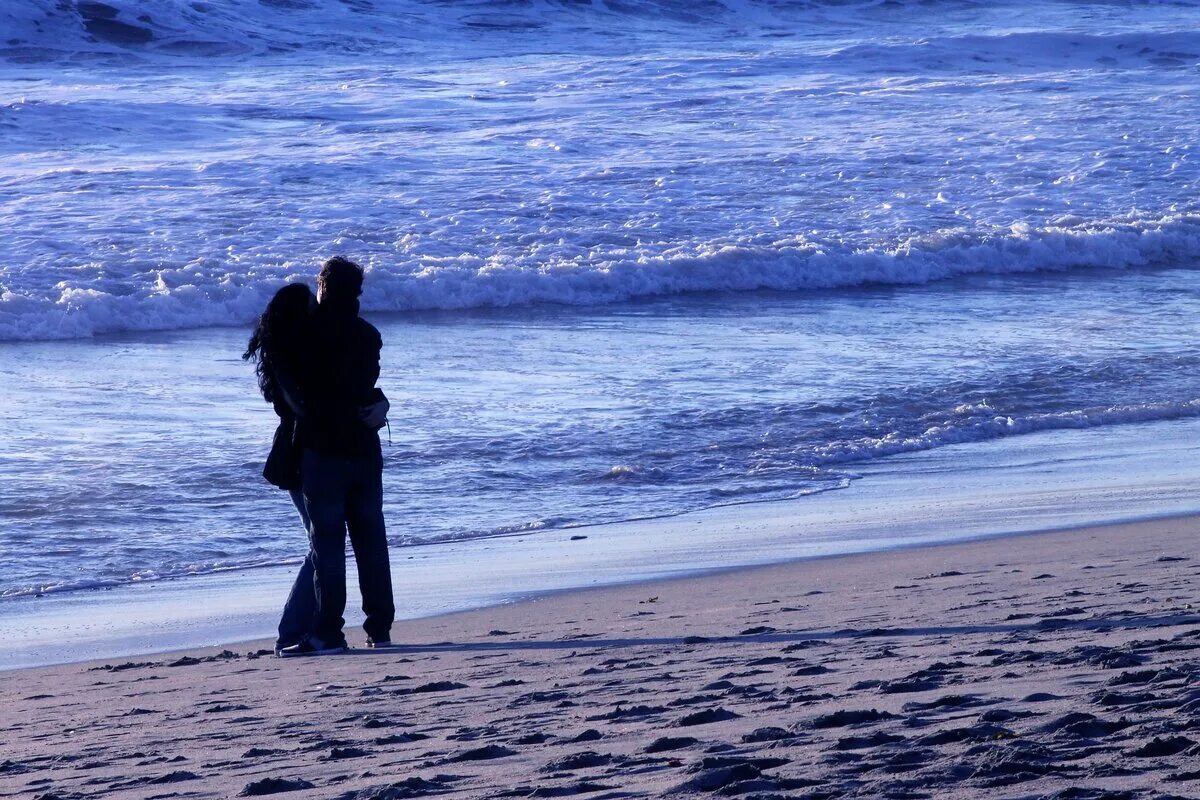 Парочка на берегу моря. Объятия на берегу моря. Пара на море. Влюбленные обнимаются у моря.