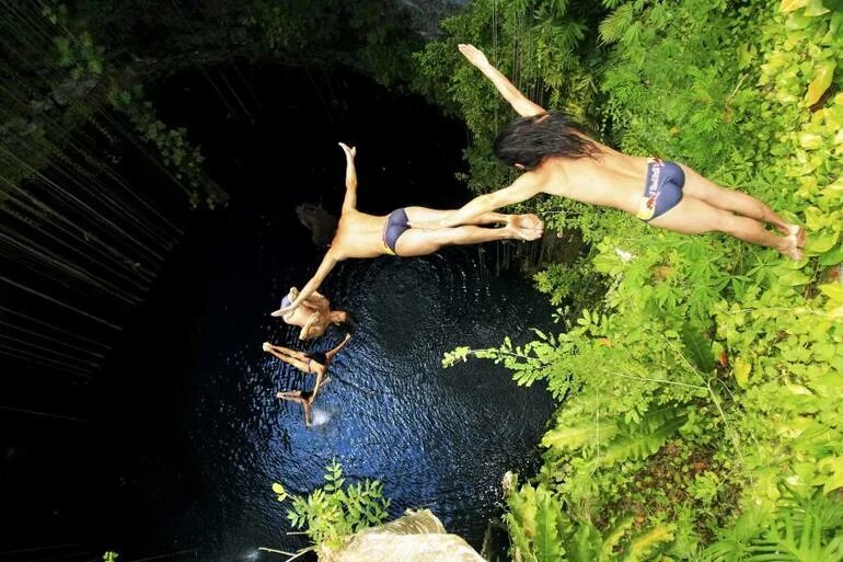 прыжок со скалы. в воду падает с большой. прыгать щучкой в воду. прыжок с обрыва в море. скалы водопад.