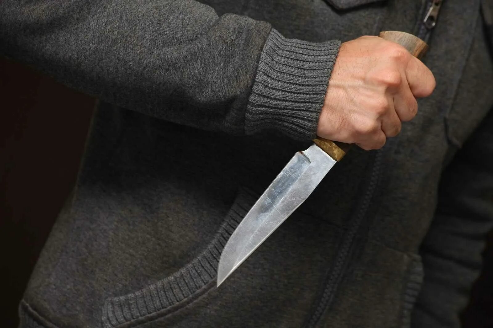 Угроза убийством лет. Мужчинская рука с ножом.