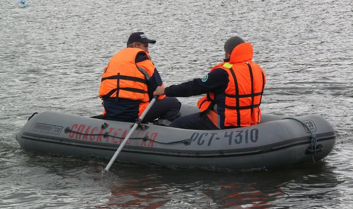 Лодки красноярск край. Спасатели на лодке. Спасательная лодка на воде. Лодка спасателей МЧС. Человек в спасательном жилете в воде.