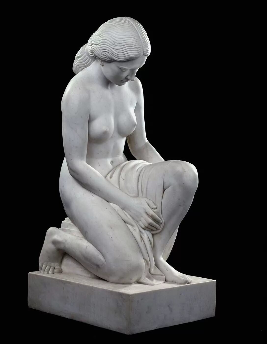 Скульптура. Скульптура спящей богини. Скульптура без фона. Женщина скульптор склоняется. Голый каменный статуй.