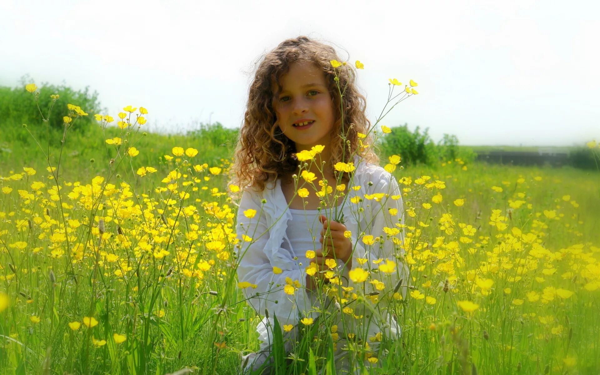 Газон лужайка. Трава у дома девочки. Детская фотосессия на природе летом. Ребенок на траве у дома. Девочка на траве улыбается.