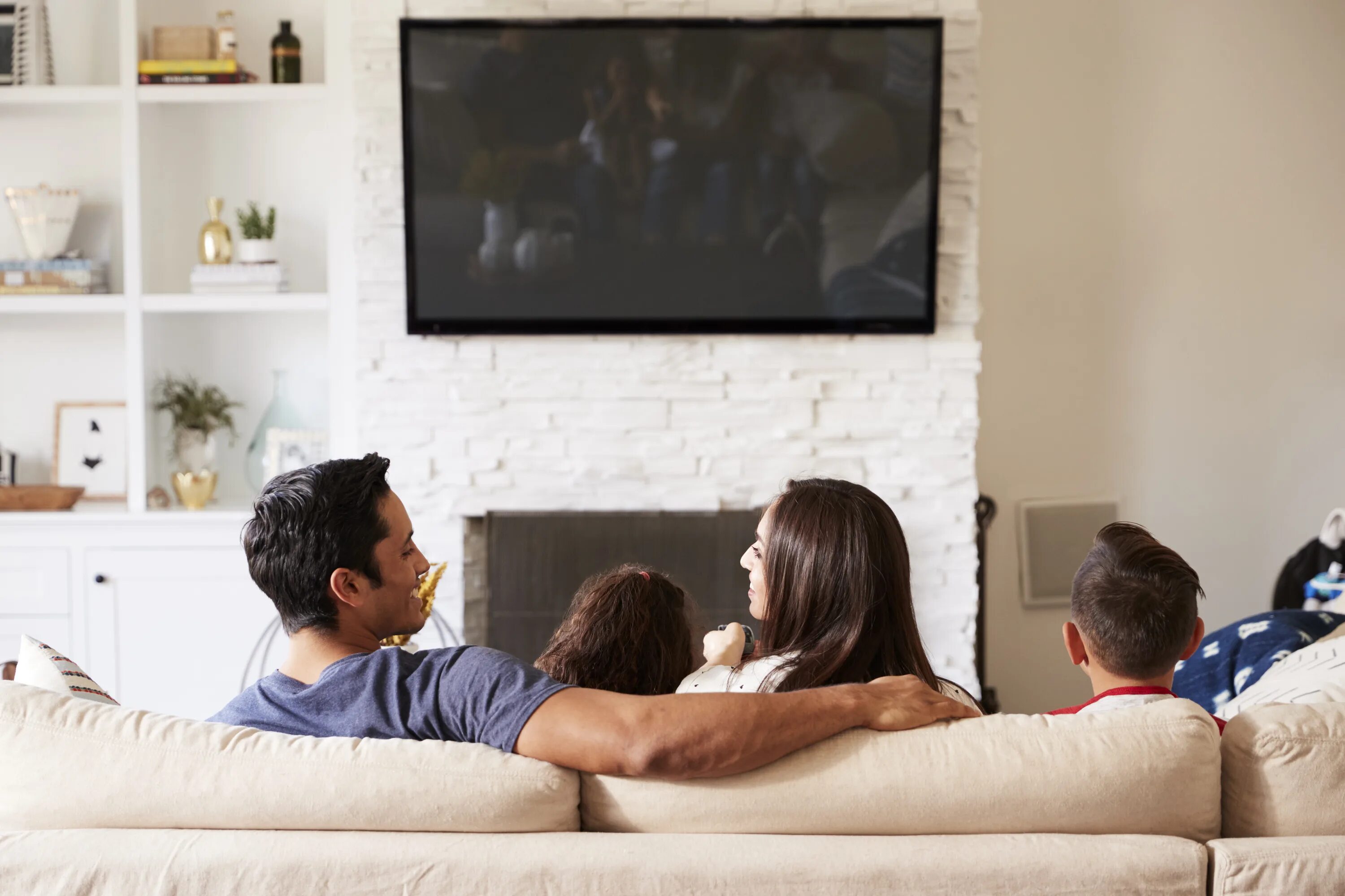 Пока муж смотрит телевизор жена. Семья в гостиной. Семья у телевизора. Семья смотрит телевизор.