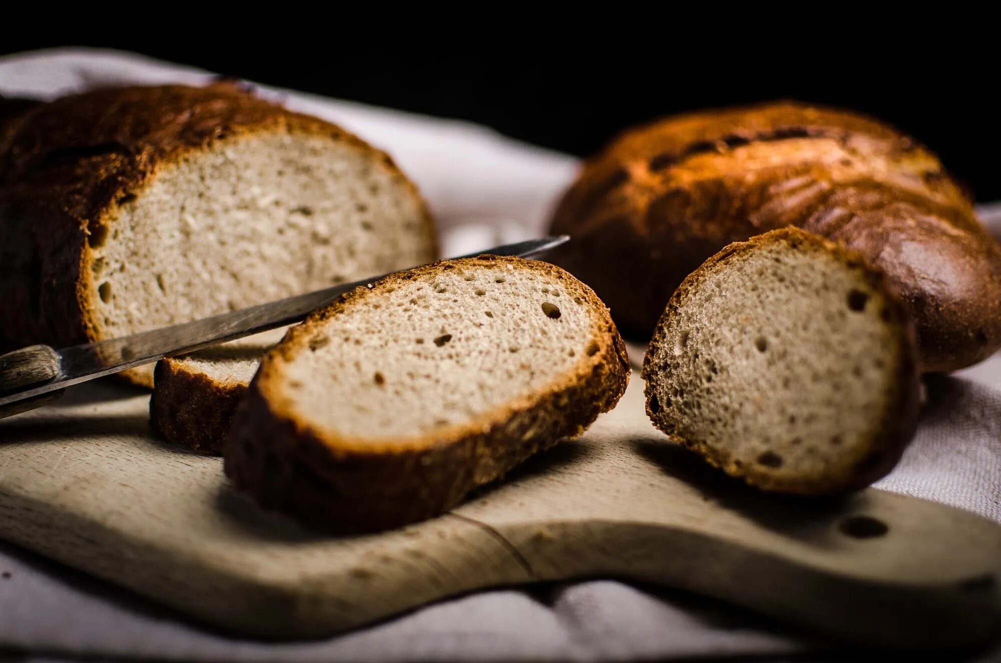 Хлеб на поминках. Выпечка хлеба. Ржаной хлеб. Хлеб на темном фоне. Пекари хлеба.