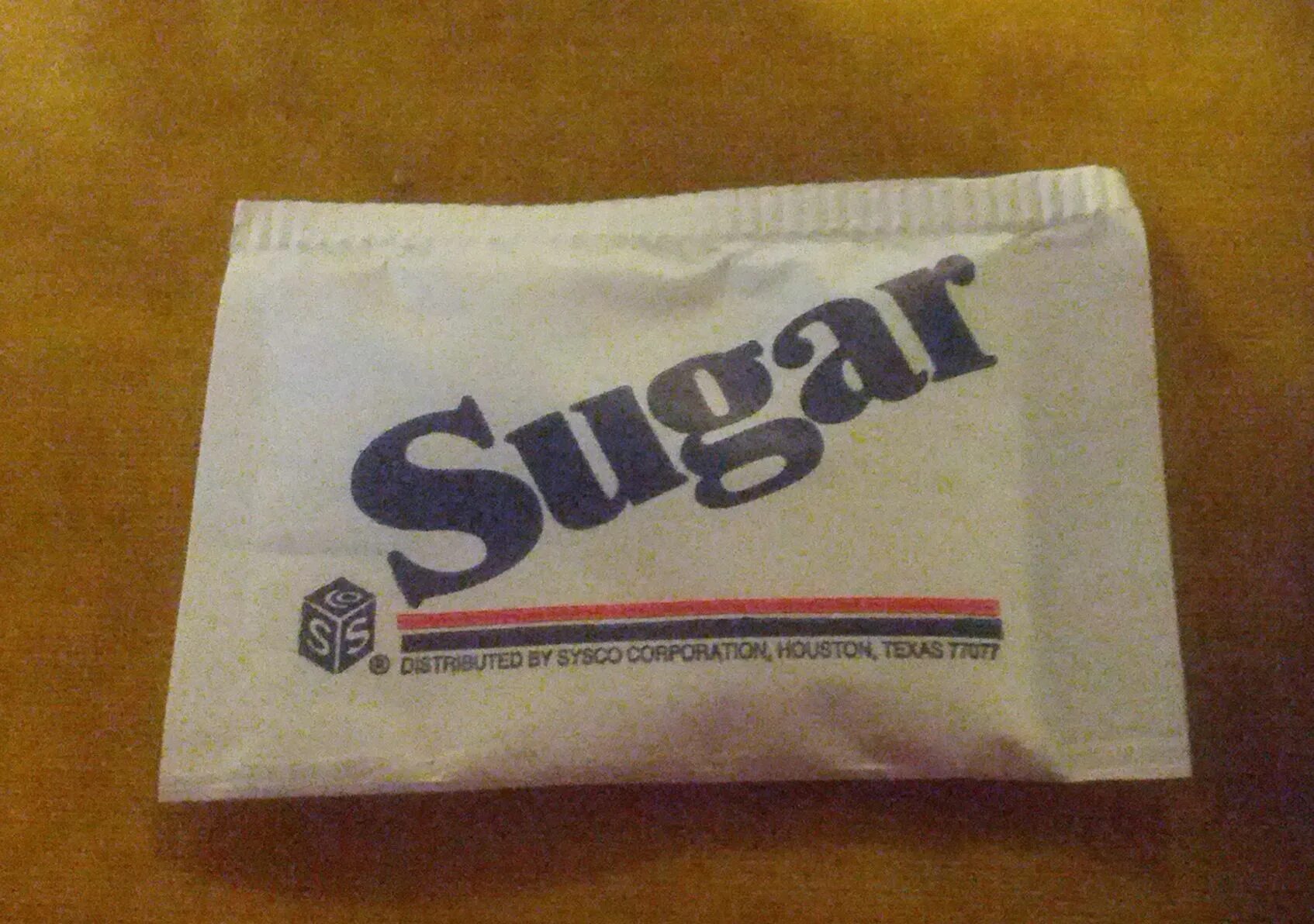 Packet of sugar. Packet. the sugar packet is torn.