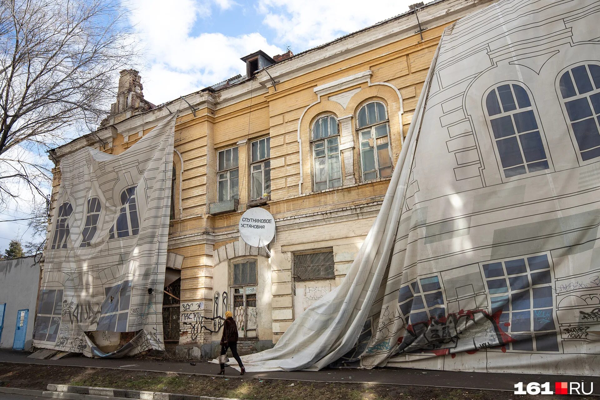 Потемкинские деревни. Входная группа в коттедж. Разрушенное кирпичное здание. Дверь красно голубая. Дом завесили баннером.