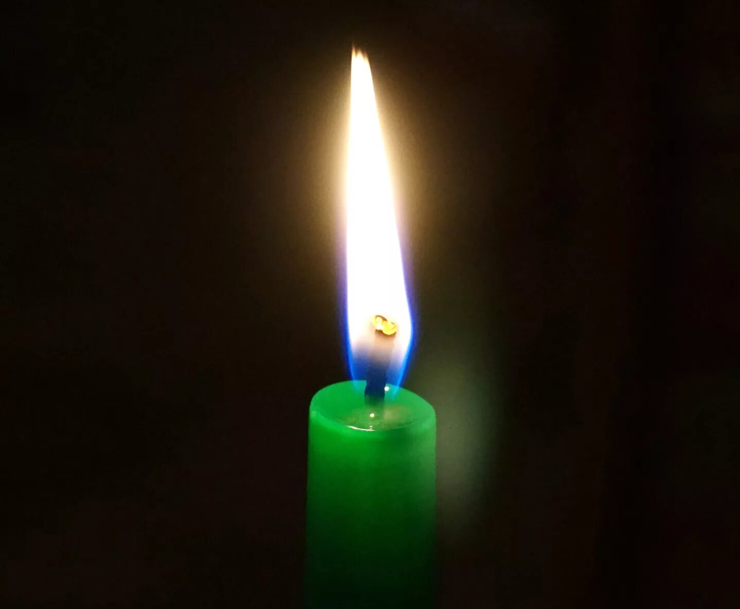 большая зеленая свеча. свеча зеленая. горящая зеленая свеча. свечи магия. зеленый огонь свечка.