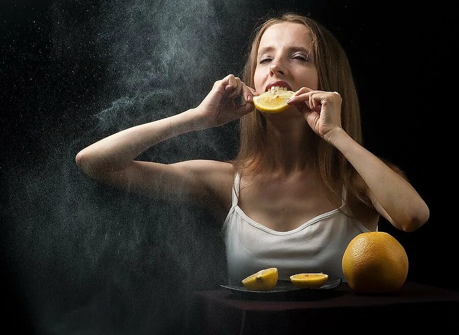 Поедание лимона. Девушка с лимоном. Кушает лимон. Девушка завтракает. Вкус удивляет