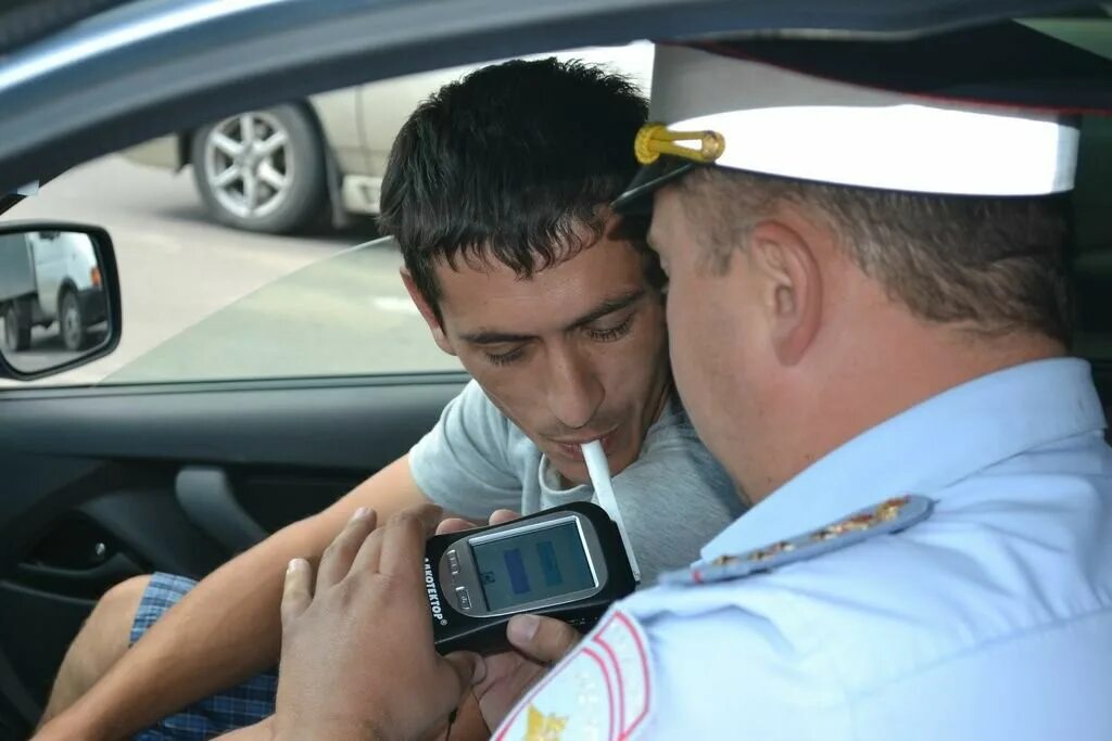 Алкотестер 2022. Освидетельствование водителей. Гаишник с алкотестером. Трубка для алкотестера. Дует в алкотестер.