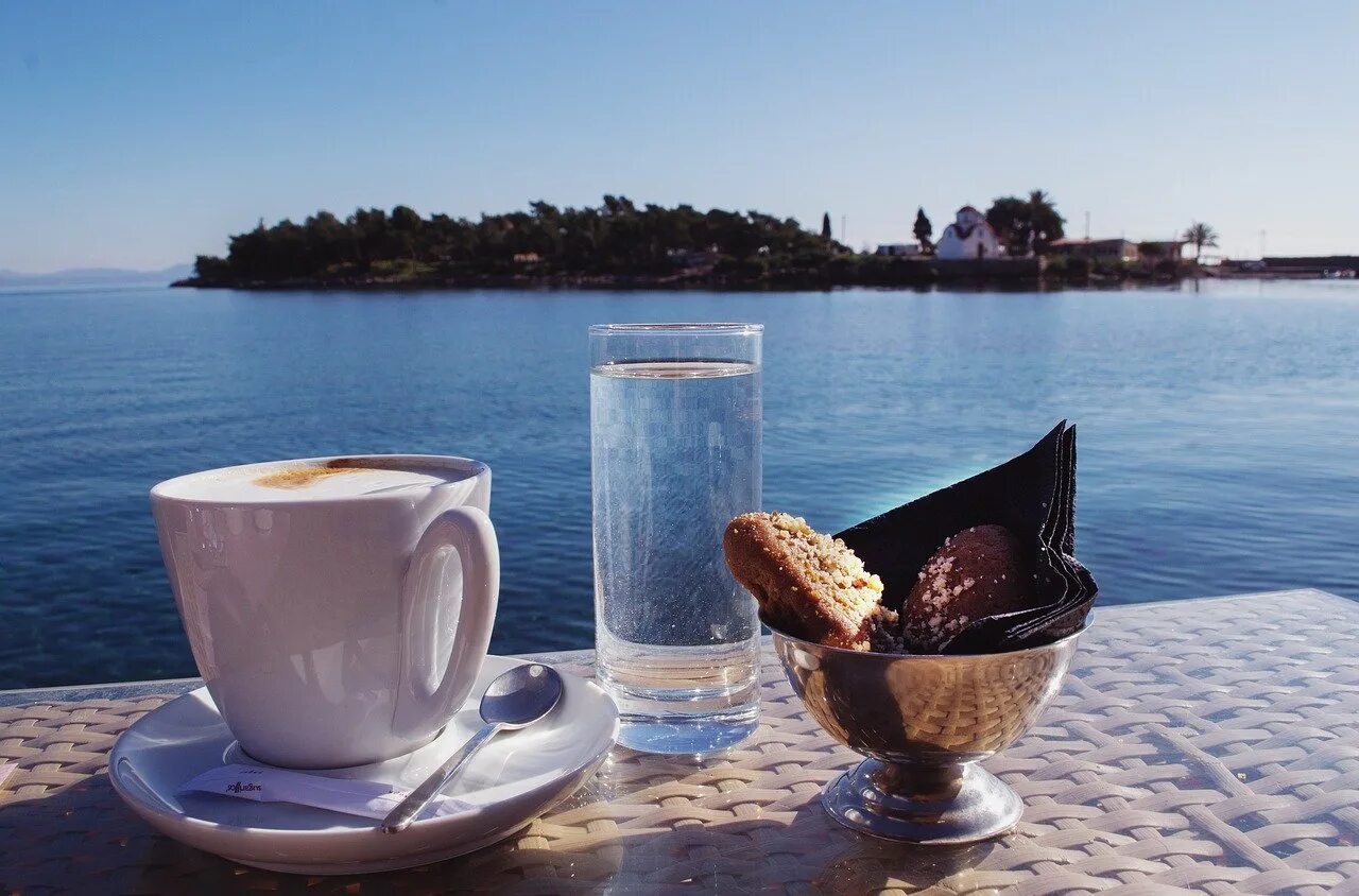 Утро ди. Чашка кофе на берегу моря. Доброе утро море. Утро на море с кофе. Чаепитие с видом на море.