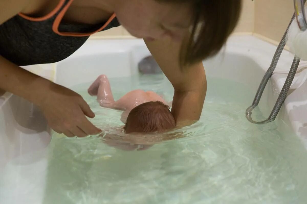 При купании новорожденного вода попадает. Грудничковое плавание в ванной уши. Купание новорожденного под краном. Грудничок захлебнул воды при купании. Мама купается с детьми в ванной.