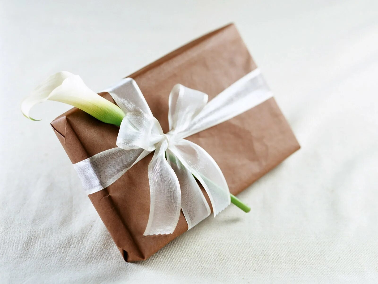 Завернуть плотно. Красивая упаковка подарков. Упаковка в крафт бумагу. Подарок в упаковочной бумаге. Упаковка подарка в крафтовую бумагу.