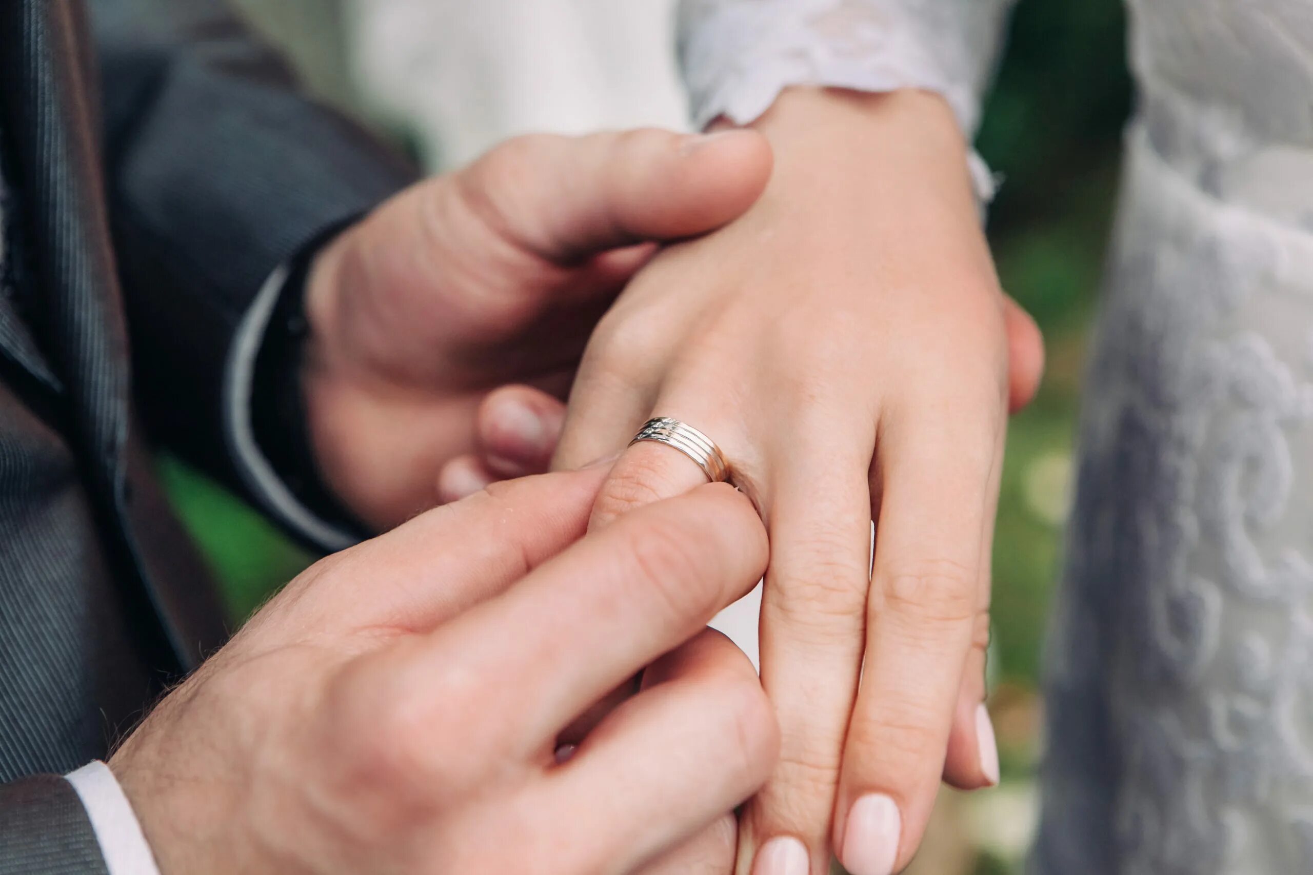 Жених надевает кольцо. Жених надевает кольцо невесте. Обручальные кольца на руках. Жених с кольцом.