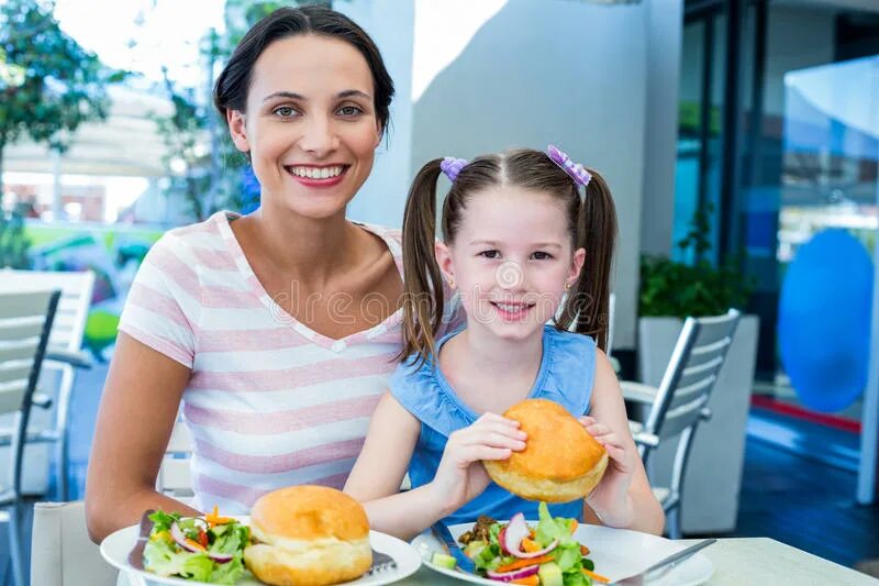 Люди едят на улице. Mother daughter Restaurant. Деловые мама и взрослая дочь за одним столом фото на прозрачном фоне. Reads book to children son and daughter. Еду маму друга