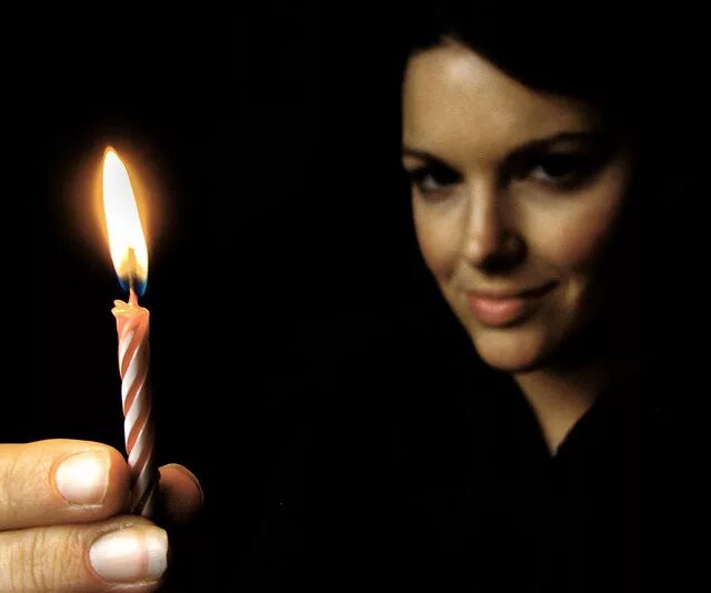 Мужчина ставит свечу. Держать свечку. Держащая свечу. Девушка со свечой в руках. Свеча в руках.