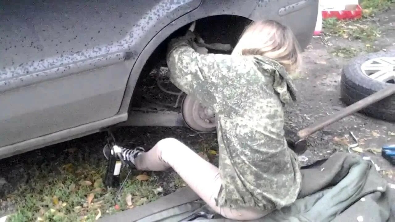Парень починил девушке машину. Девушка под машиной ремонтирует. Женщина под машиной. Женщина меняет колесо. Девушки меняют колесо на машине.
