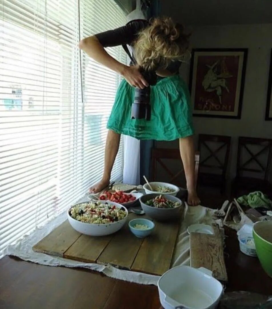 Фотосессия с едой. Девушка на столе с едой. Девушка фотографирует еду. Смешные фотографии с едой.