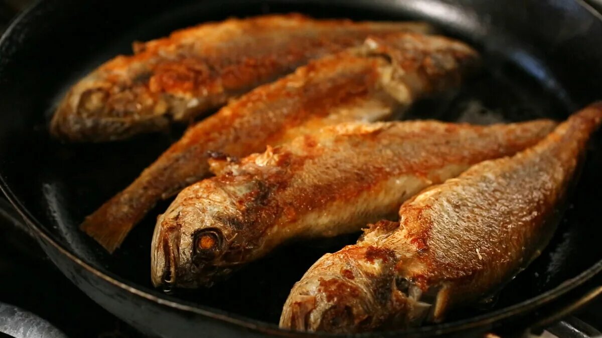 Какую жареную рыбу. Рыба жареная. Рыба на сковороде. Рыбка на сковороде. Рыба жарится на сковородке.