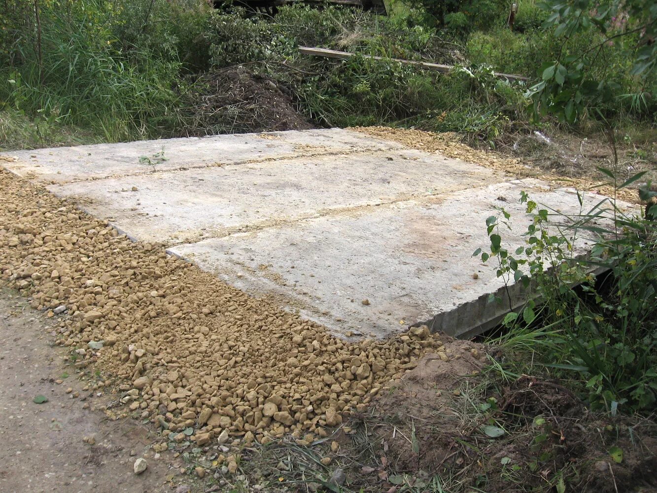 Покрытие из дорожных плит. Заезд на участок через канаву. Плита на заезд на участок через канаву. Заезд на участок через канаву дорожными плитами. Укладка плиты через канаву.