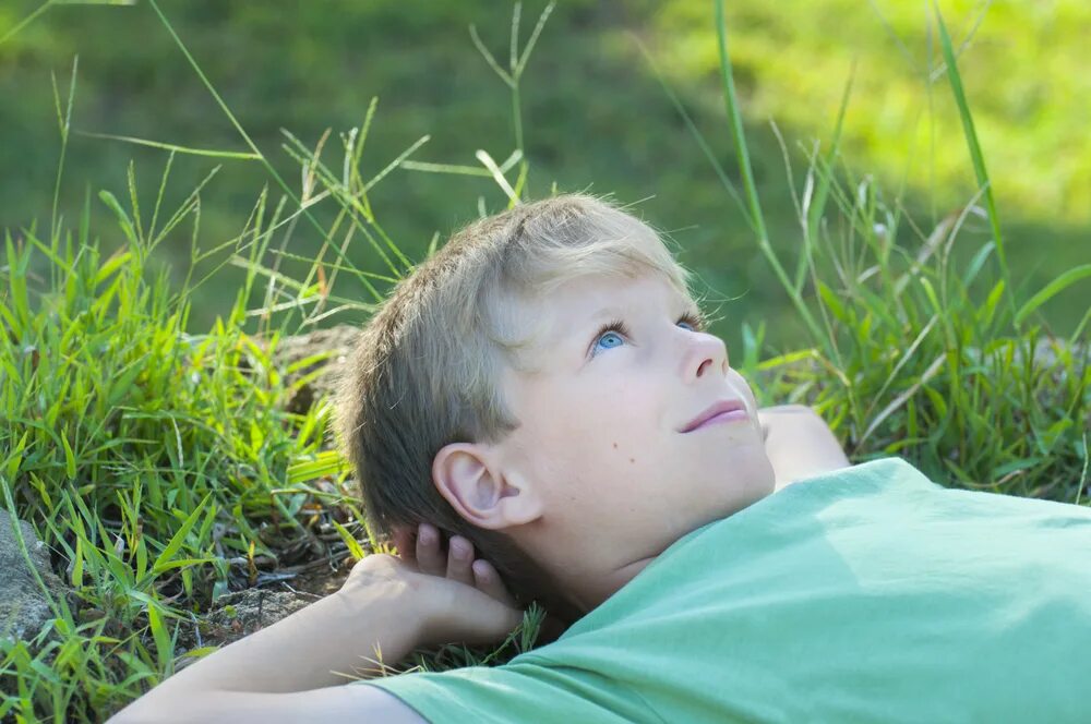 Мальчик лежит на траве. Мальчик лежит. Мальчик на траве. Мальчик на травке дети.