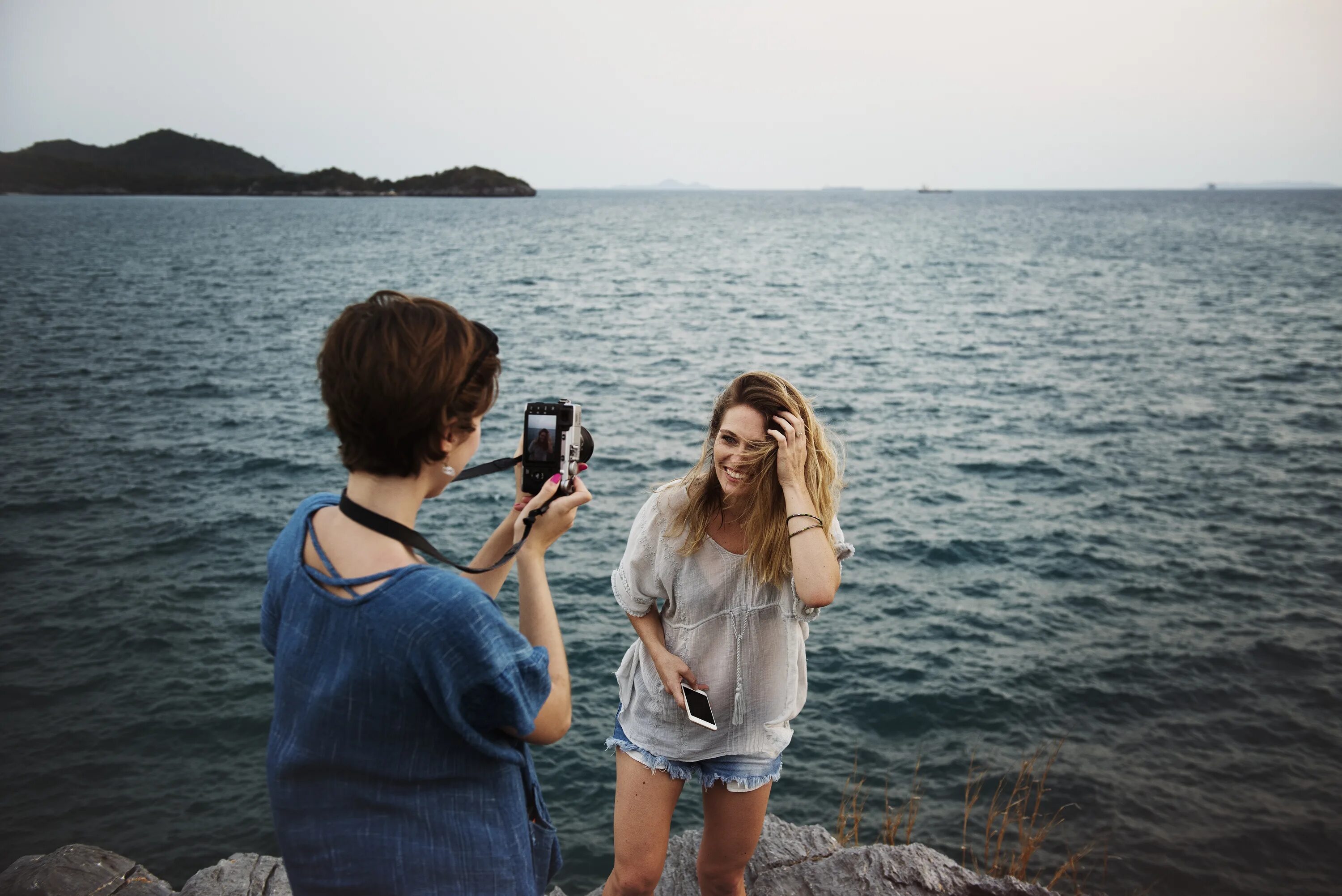 Девушка фотографирует. Девушка фотографирует море. Подружки фотографируются. Путешествие с подружками.