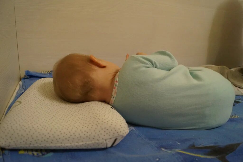 Подушка новорожденному с какого возраста. Подушка для новорожденного. Ортопедическая подушка для новорожденного. Подушки детские ортопедические для сна. Ортопедическая подушка для малышей до года.