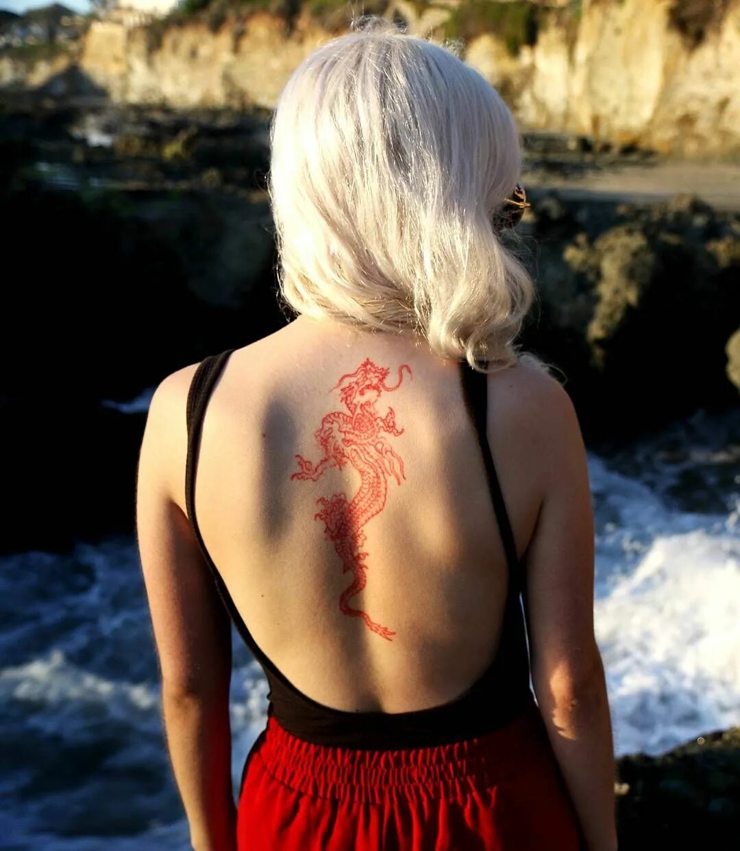 Татуировка на спине у девушки. Красное тату на спине у девушки. Тату дракон на спине у девушки. Тату на спине для девушек.