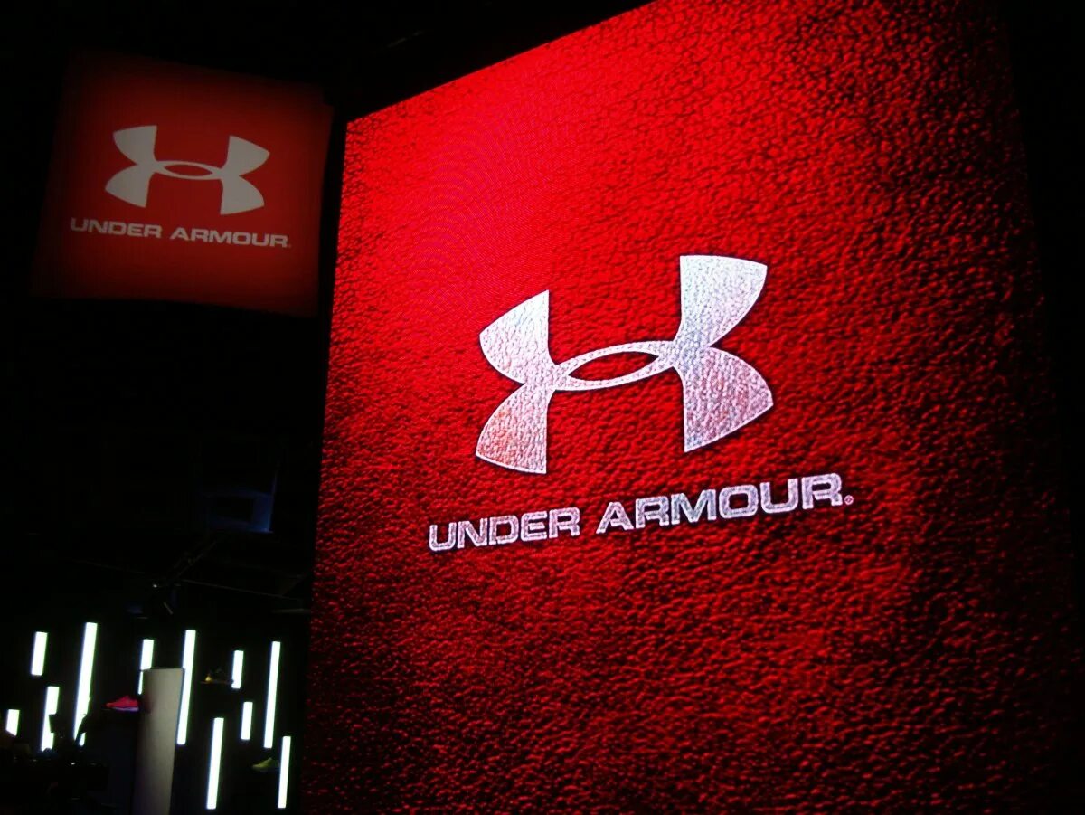 Under бренд одежды. Бренд андер армор. бренд спортивной одежды under armour. спортивный бренд андерамоо. андер армор логотип.