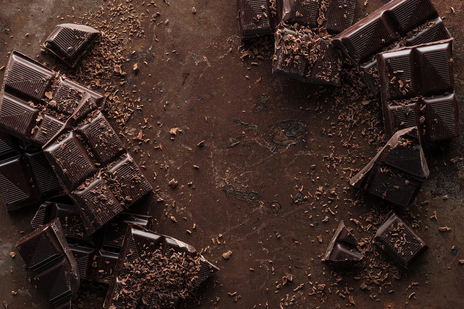 Шоколад подорожает. Шоколад на столе вид сверху. Куски шоколада вид сверху. Стружка шоколада. Шоколадный батончик вид сверху.