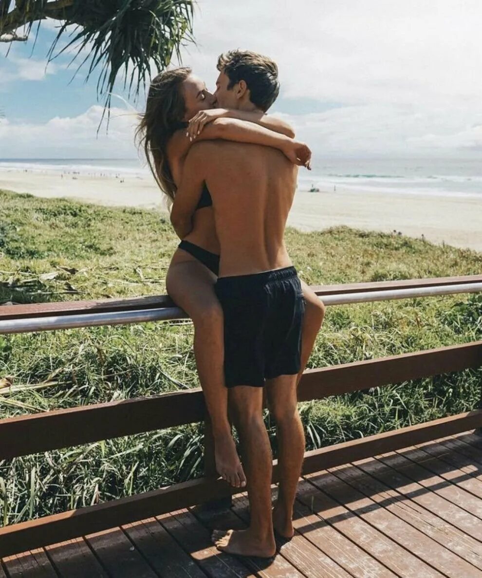 Мужчина в женском купальнике. Пара на пляже. Парень и девушка на море. Пара на пляже. Мужчина и женщина на шезлонге.