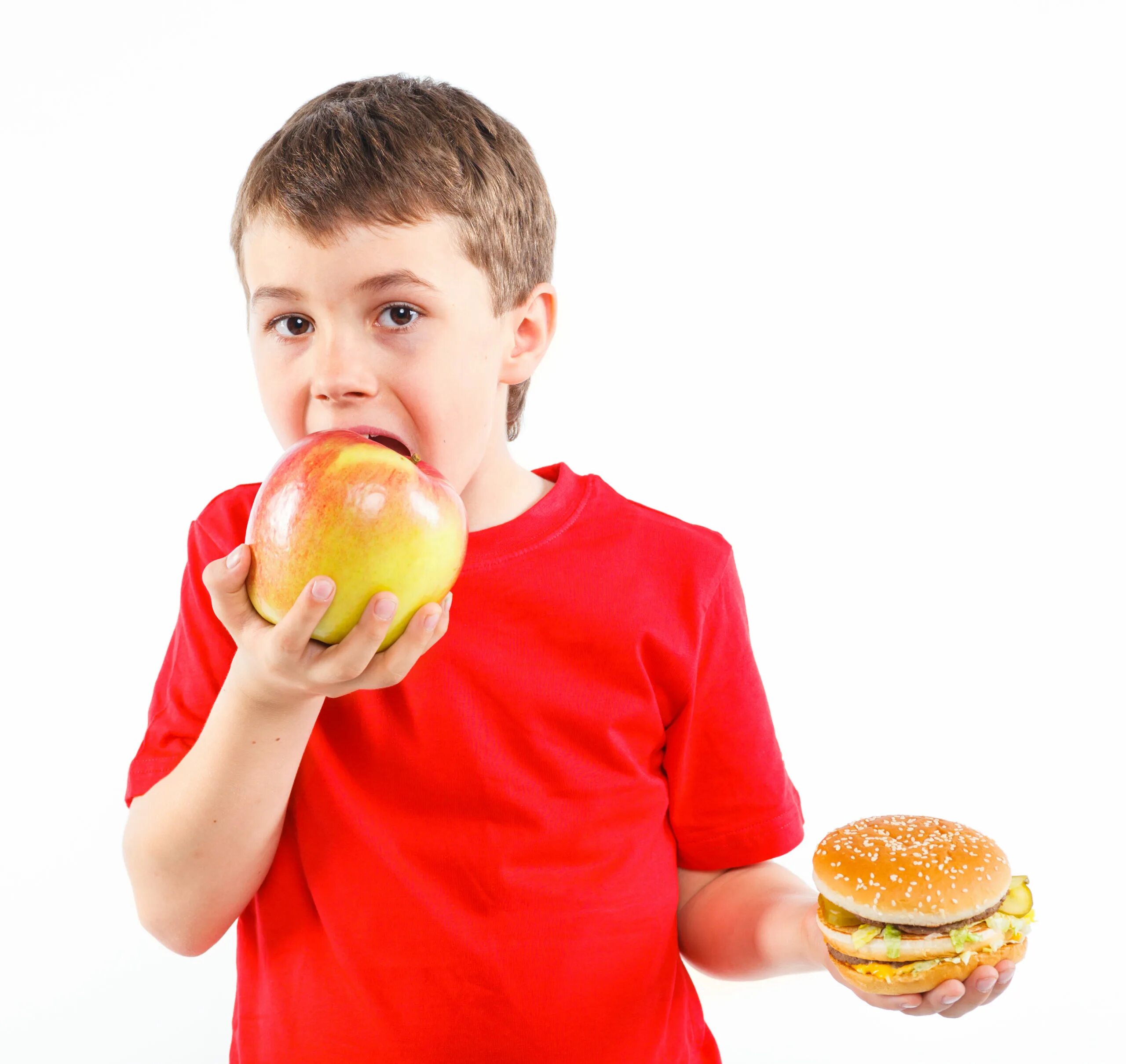 Мальчик с бургером. Мальчик ест. Ест яблоко. Мальчик ест на белом фоне.