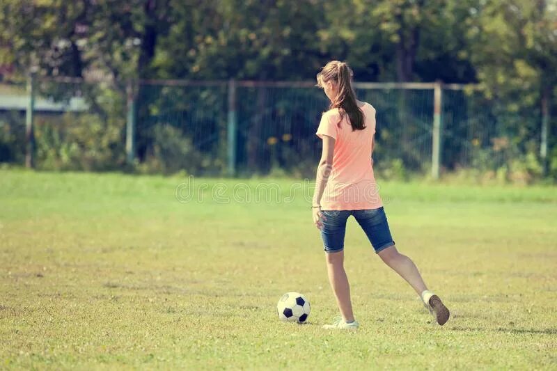 Девочка пинает мяч. Девушка пинает мяч. Девушка играет в футбол. Девушка пинает футбольный мяч. В футбол играли женщины