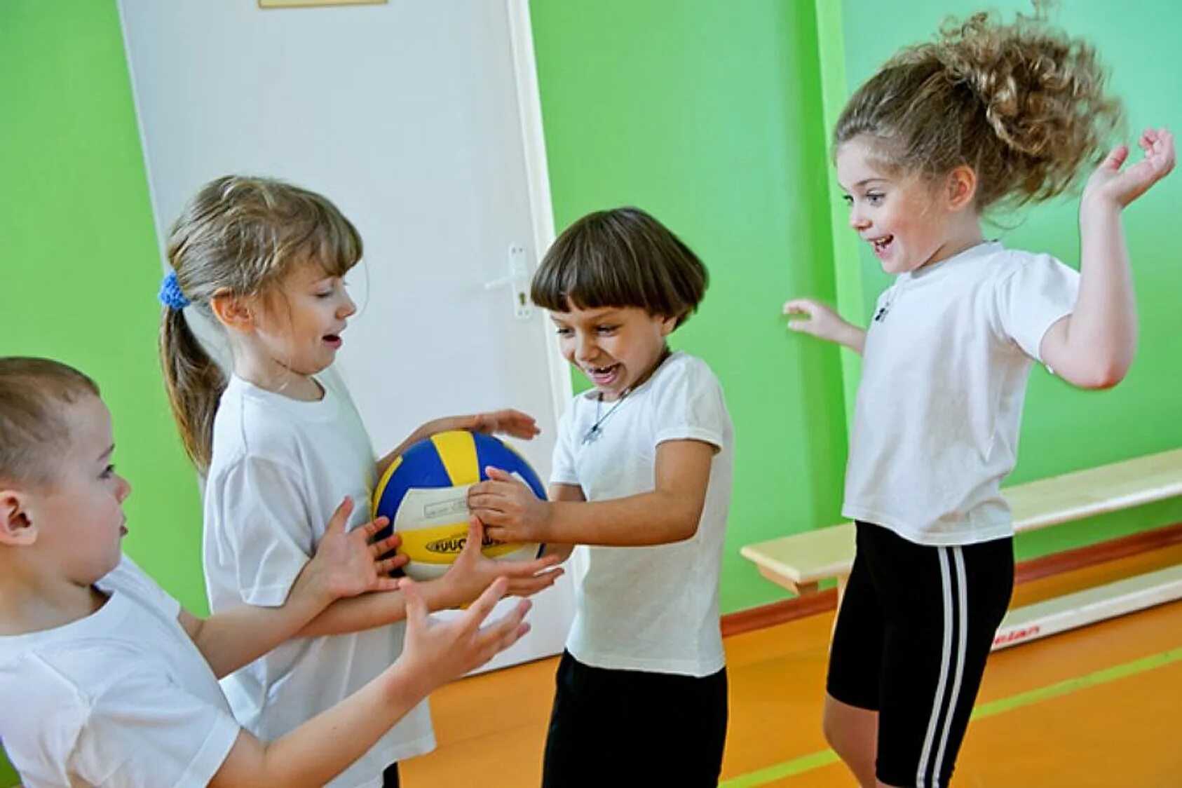 Одна из первых игр с мячом. Дети на физкультуре в детском саду. Занятия физкультурой в школе. Физкультура в садике. Младшие дошкольники в игре.