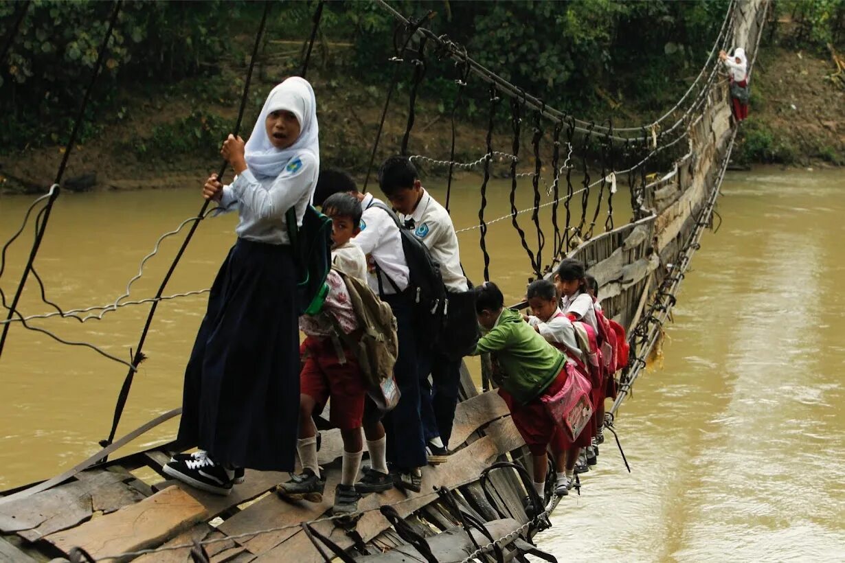 Человек шел через реку. Опасная дорога в школу. Самая опасная дорога в школу. Подвесной мост в Индонезии. Самые опасные дороги в школу.