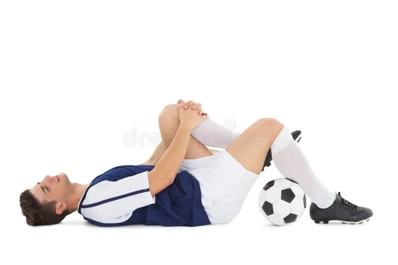 Футболист лежит. Футболист лежит на газоне. Ноги футболиста лежа. Футболист лежа позирует с мячом. После футбола болит