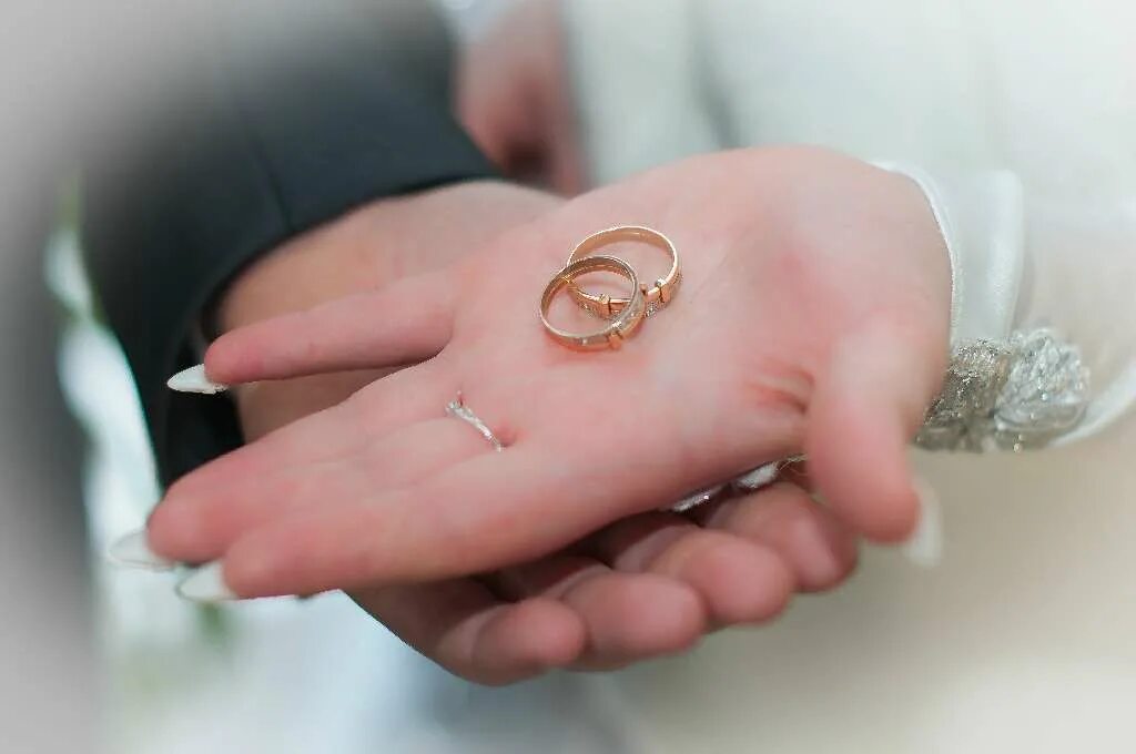 Свадебные кольца на пальцах. Сломанное обручальное кольцо. Разбитые обручальные кольца. Треснутые обручальные кольца.