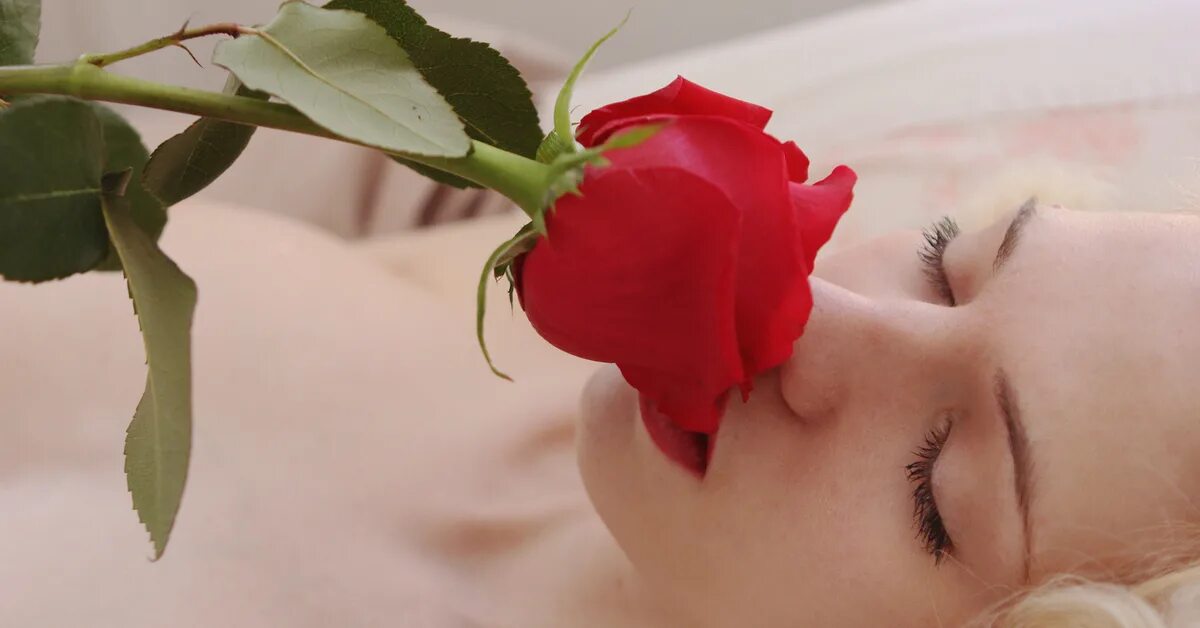 Нюхает спящую девушку. Девушка нюхает розу. блондинка нюхает розу. роза на груди. красивая девушка нюхает розу.