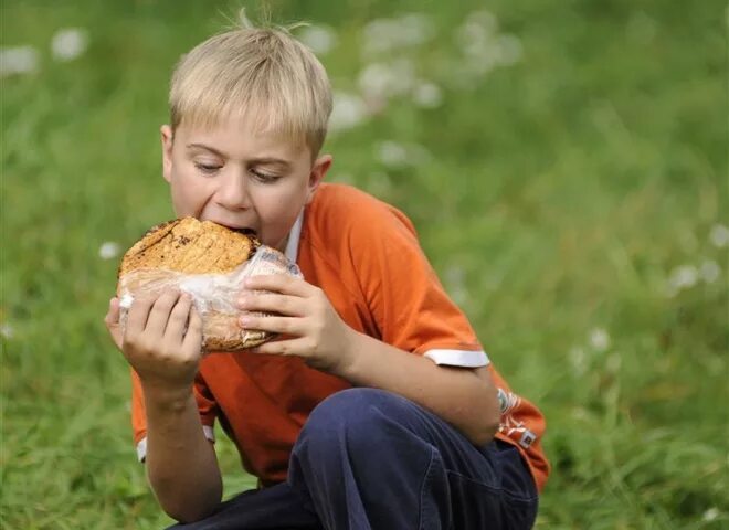 Человек есть хлеб. Мальчик с хлебом. Мальчик ест хлеб. Мальчик с булочкой. Парень ест булочку.