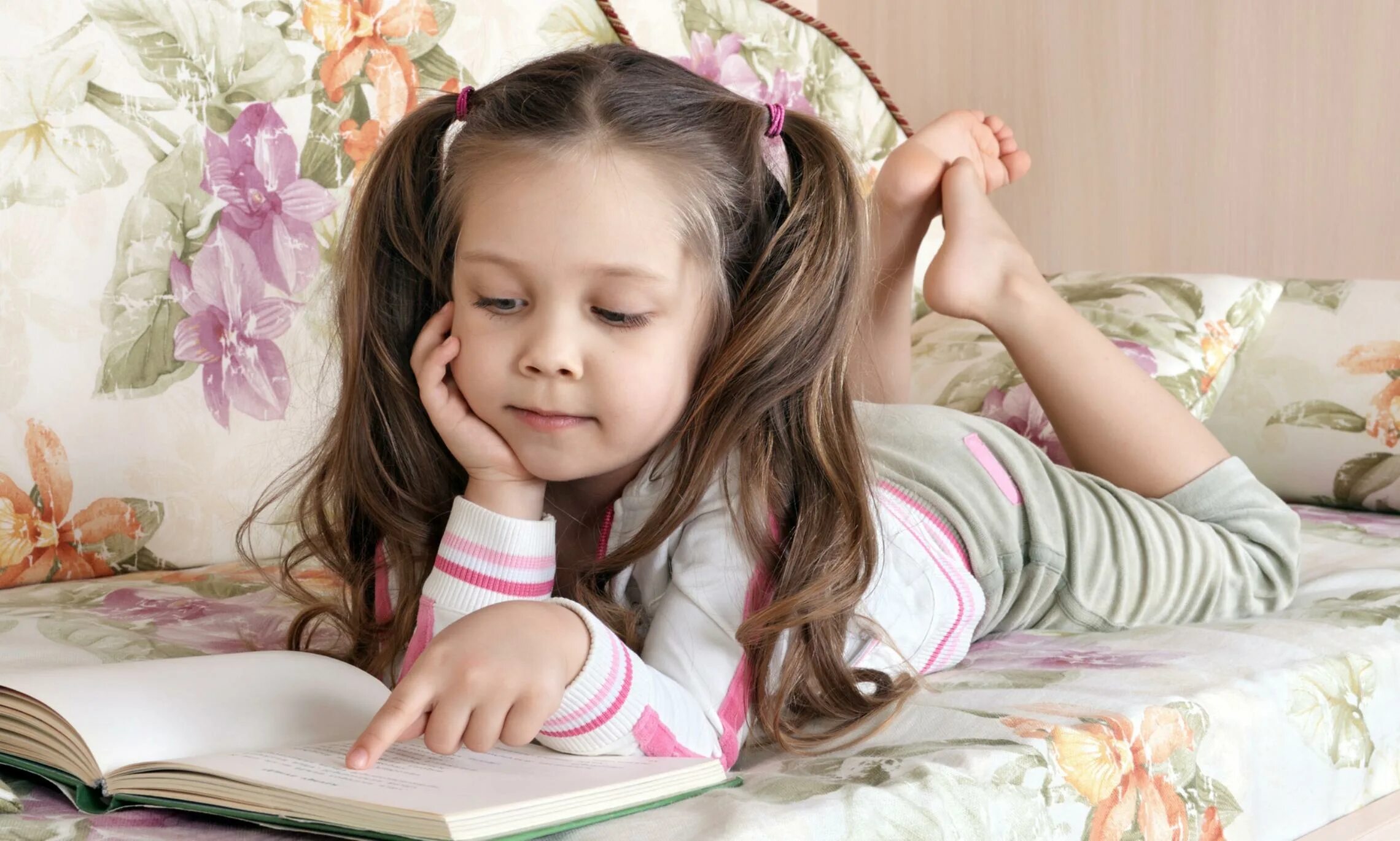 Читаем смотрим едим. Маленькая девочка с книгой лежит. Чтение лежа. Чтение книг лежа. Чтение лёжа ребёнок.