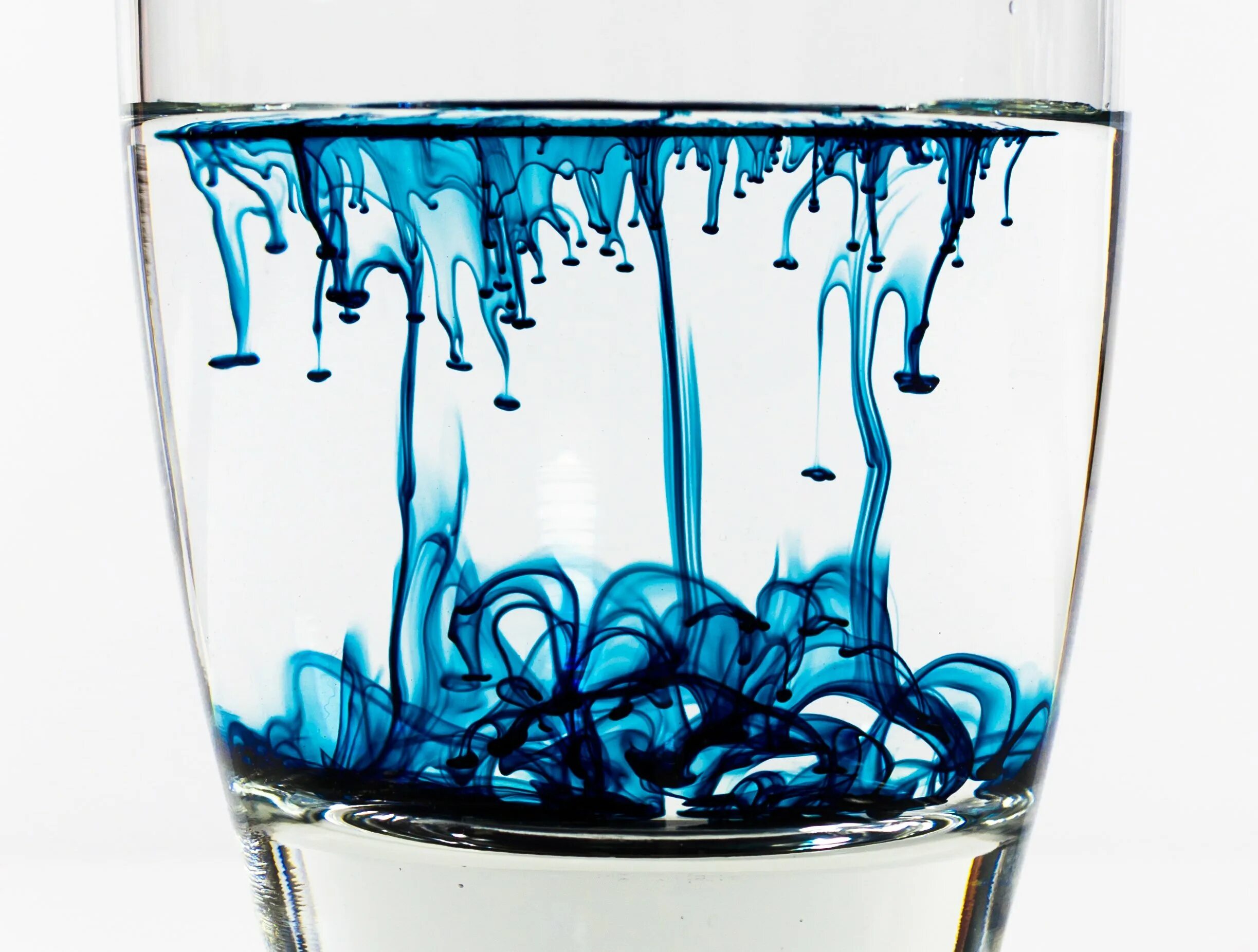Стакан с разноцветной водой. Стакан с жидкостью. Краска в бокале с водой. Вода растворяет краску. Растворение льда