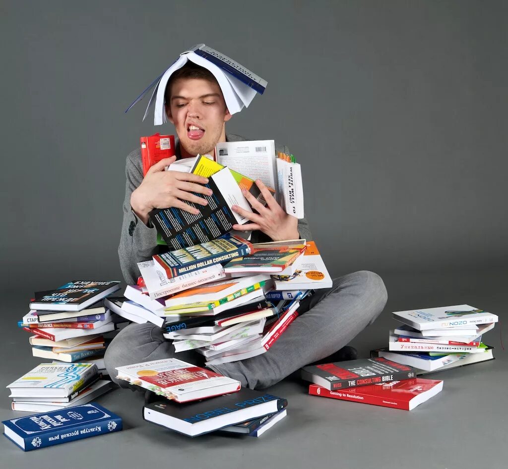 Устаю читать. Человек заваленный книгами. Книжные завалы. В завале книг. Студент с кучей бумаг.