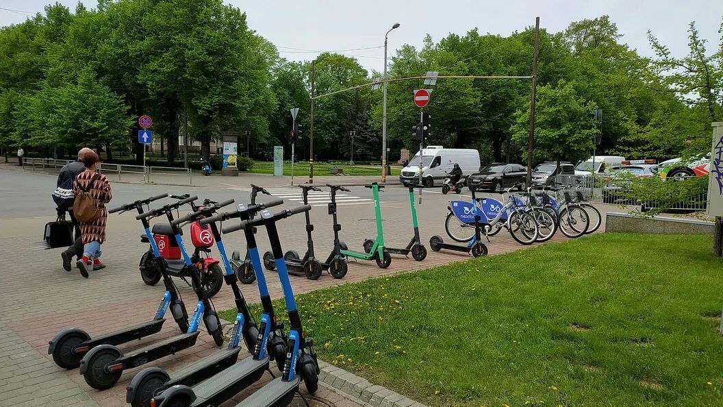 Самокат спб на улице. Кикшеринг самокатов в маленьком городе. Самокаты в парке Победы Севастополь.