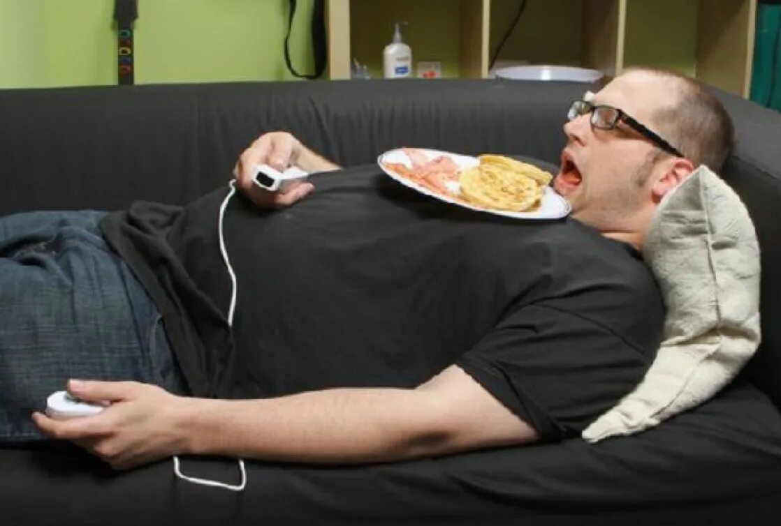 Еда лень. Ленивый человек. Толстый ленивый человек. Толстый человек на диване.