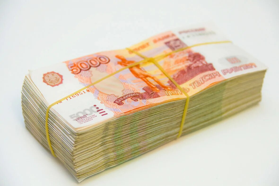 огромная стопка денег. пачка рублей. пачки купюр по 5000 рублей. пачка пятитысячных купюр. пачка денег.