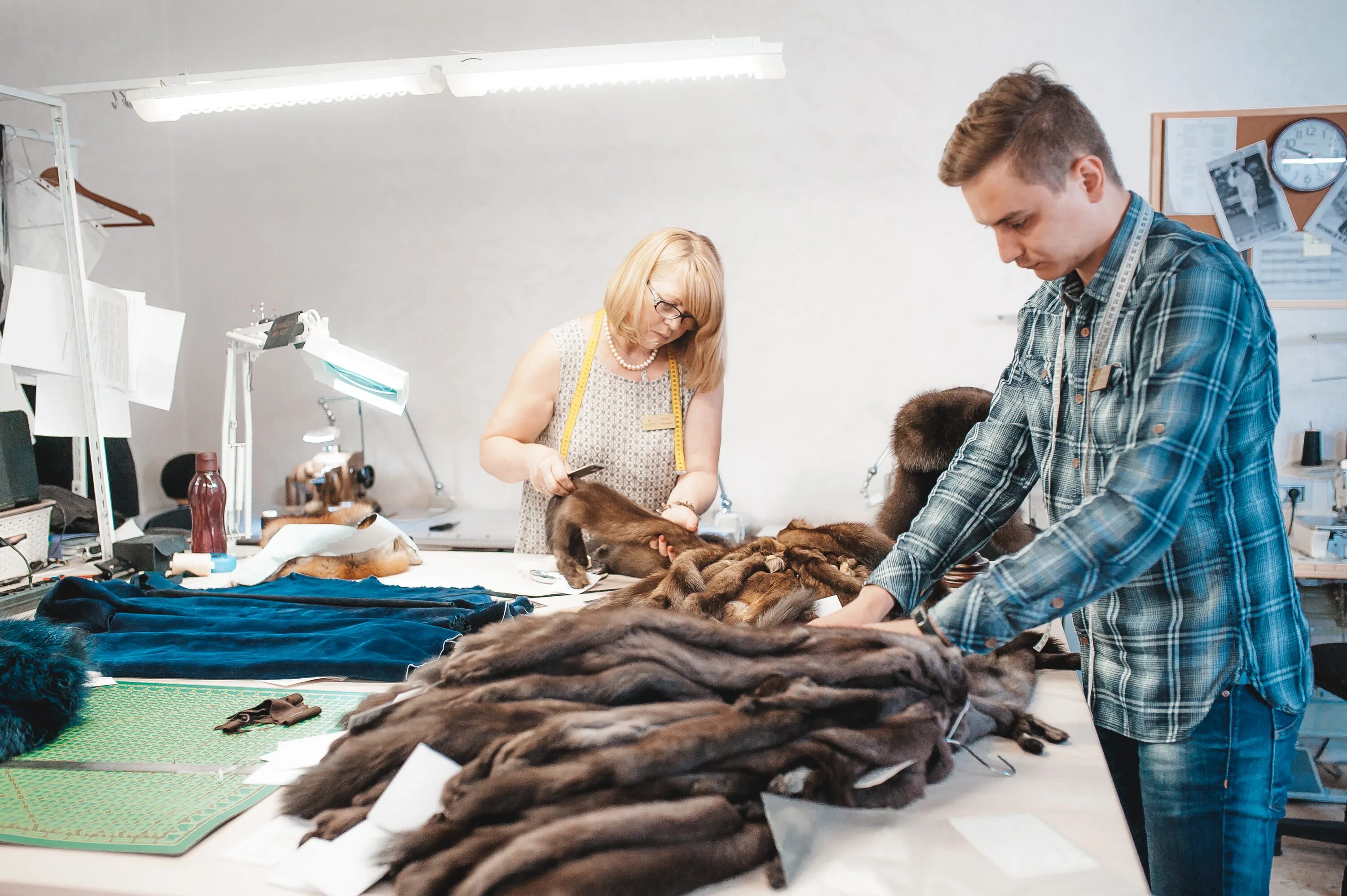 Швейная машинка шьет мех. Раскройщик кожевенного сырья. Работа скорняком. Цех по пошиву кожаных изделий. Стол скорняка.